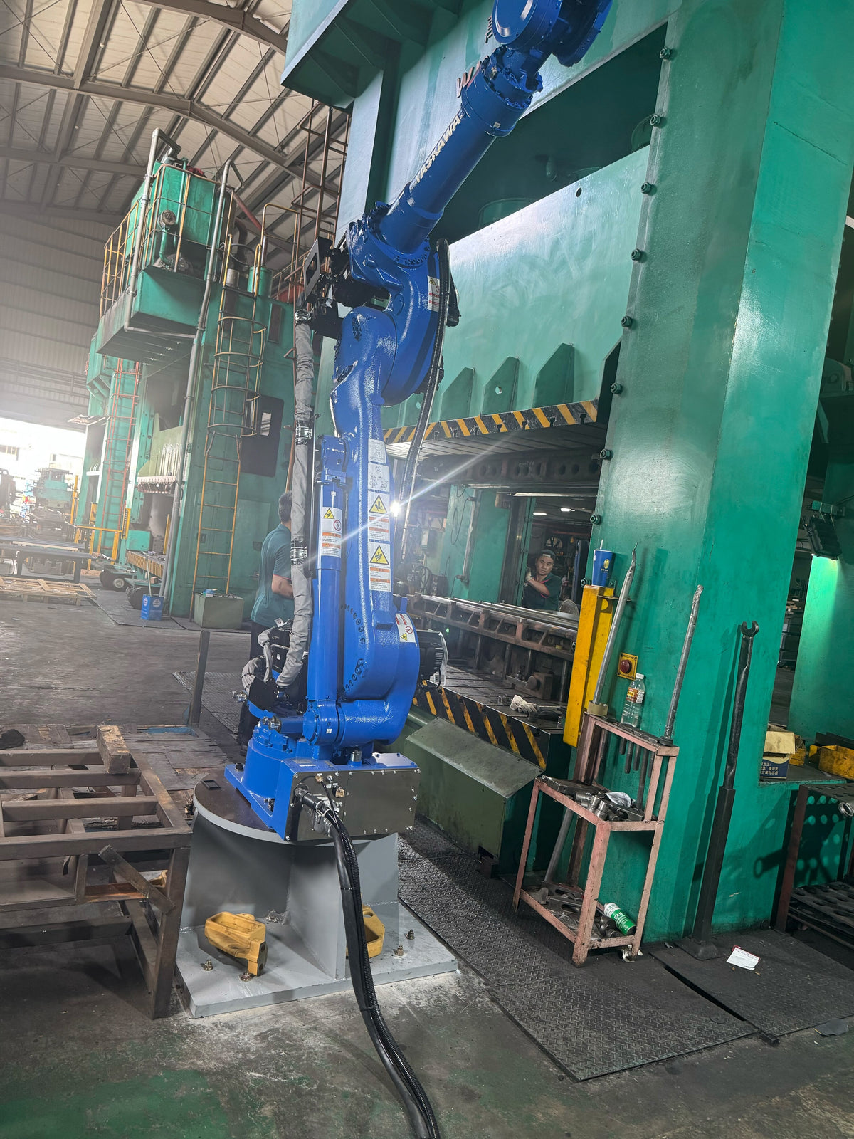 Robotic arm serving a stamping press